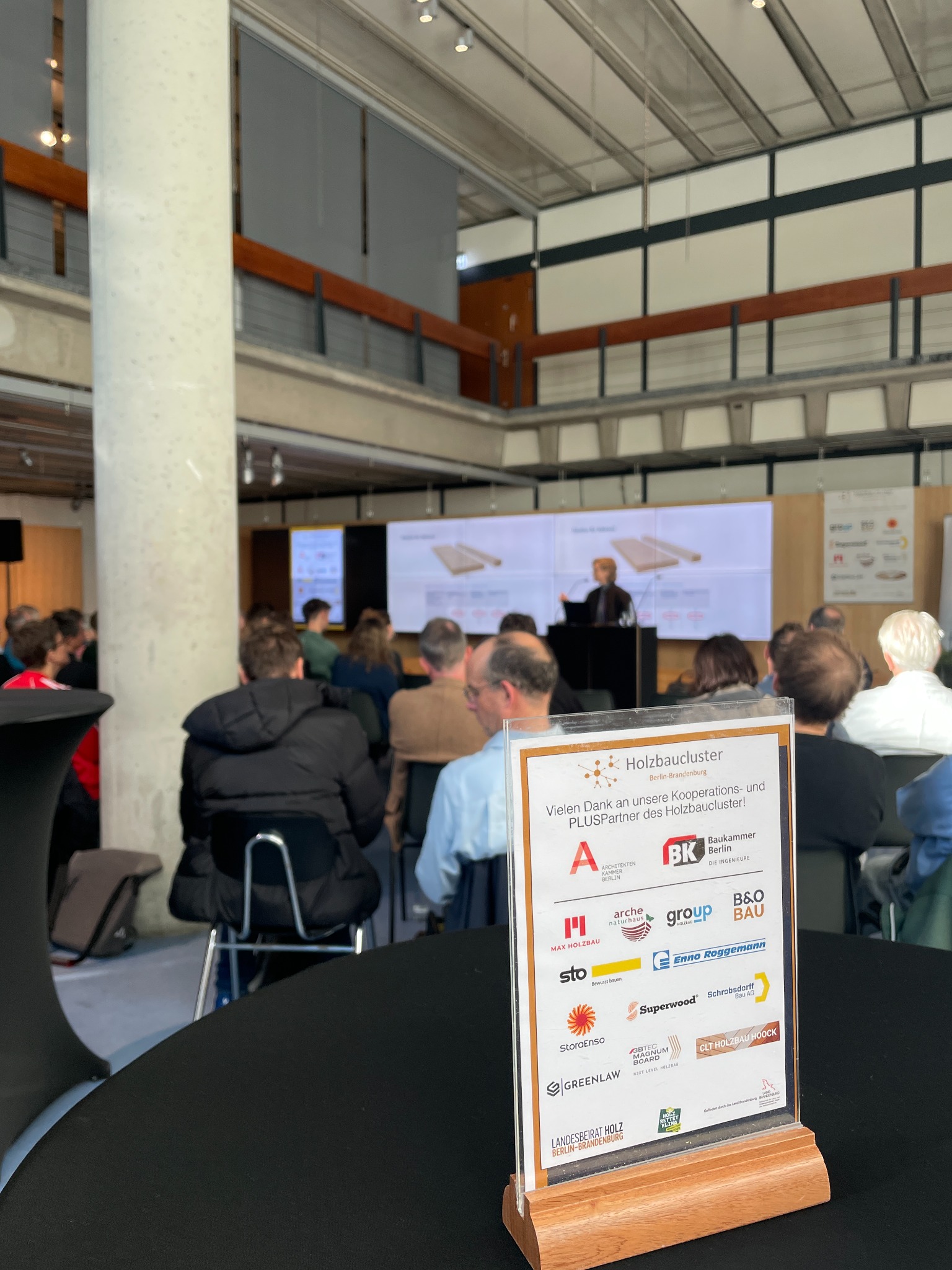 Fachseminar mit Vortrag und Aufsteller der PLUS-Partner im Veranstaltungsraum